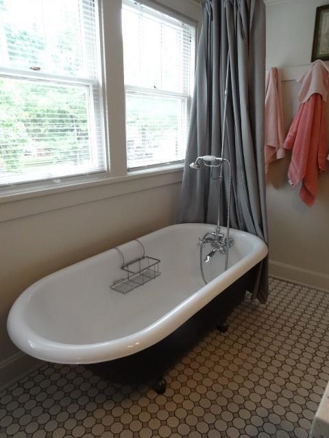 full bathroom featuring a soaking tub and baseboards