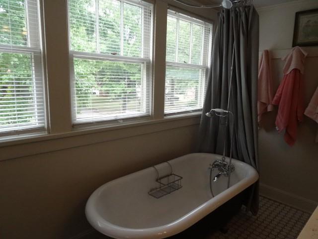 bathroom with a freestanding tub, plenty of natural light, and baseboards