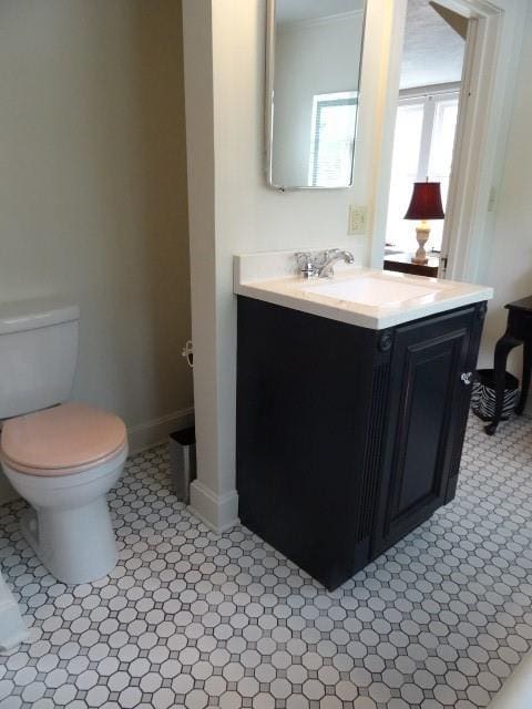 bathroom featuring vanity, toilet, and baseboards