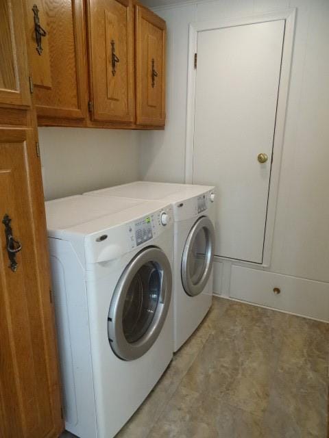 laundry area featuring washing machine and clothes dryer and cabinets