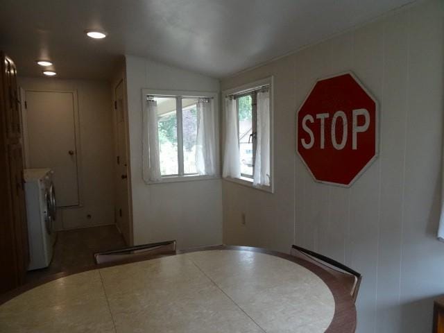 dining room featuring a baseboard radiator, vaulted ceiling, and washer and clothes dryer