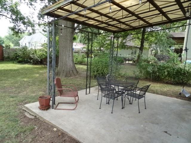 view of patio featuring fence, outdoor dining area, and a pergola