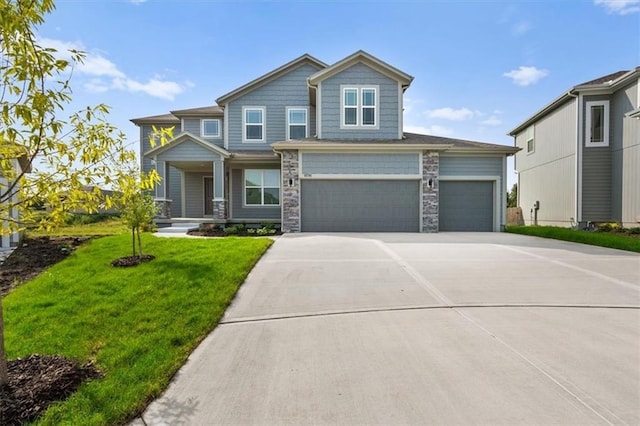 craftsman inspired home featuring a front lawn, stone siding, and driveway