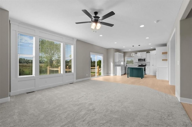 unfurnished living room featuring visible vents, baseboards, light colored carpet, recessed lighting, and a ceiling fan