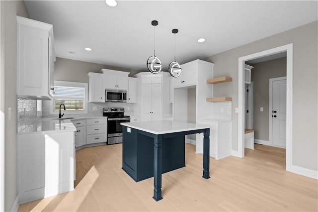 kitchen with a kitchen island, white cabinetry, light wood-style floors, appliances with stainless steel finishes, and decorative backsplash