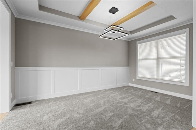 empty room with visible vents, ornamental molding, a decorative wall, and carpet floors