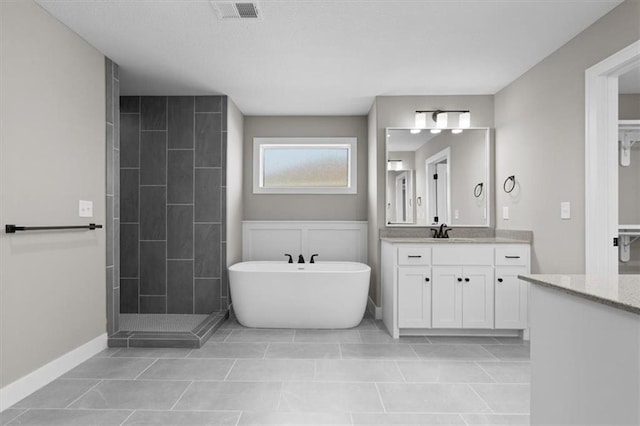 bathroom featuring visible vents, tile patterned flooring, tiled shower, a soaking tub, and vanity