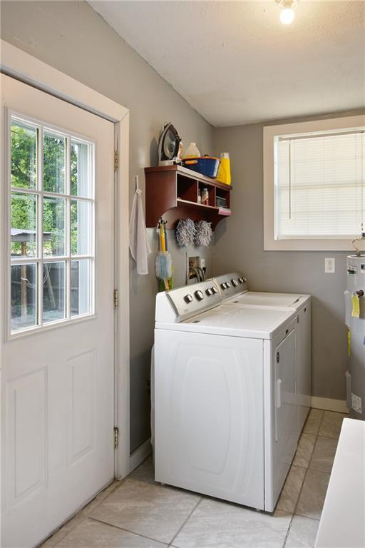 laundry area featuring laundry area, water heater, baseboards, and independent washer and dryer