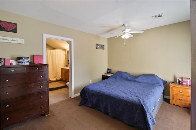 bedroom with light carpet, baseboards, visible vents, and connected bathroom