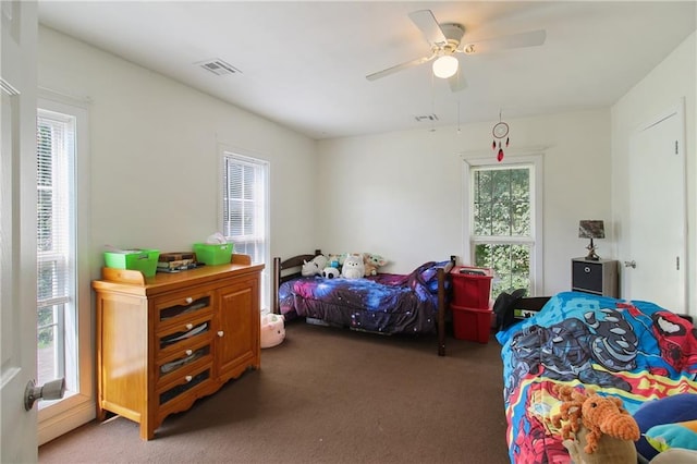 bedroom with ceiling fan, dark colored carpet, and visible vents