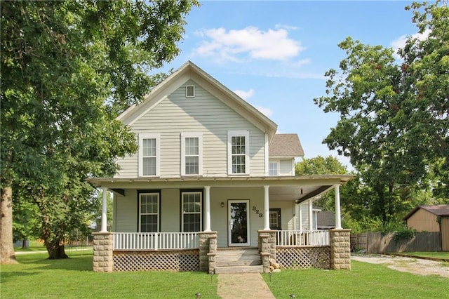 farmhouse inspired home featuring covered porch, fence, and a front yard