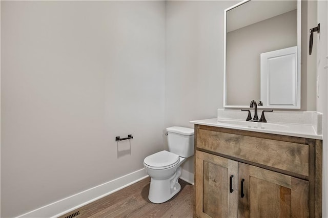 bathroom featuring toilet, hardwood / wood-style floors, and vanity