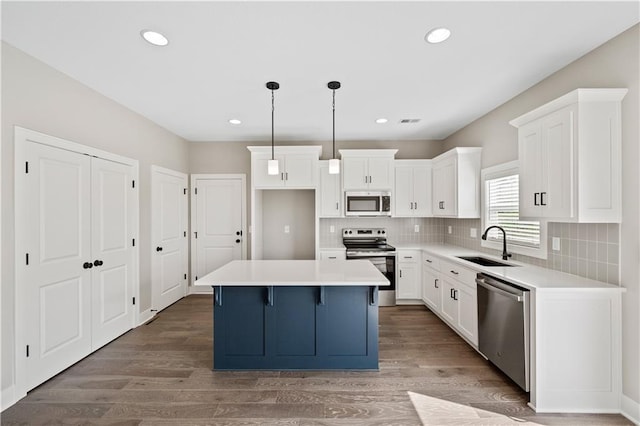 kitchen featuring sink, tasteful backsplash, a kitchen island, stainless steel appliances, and pendant lighting