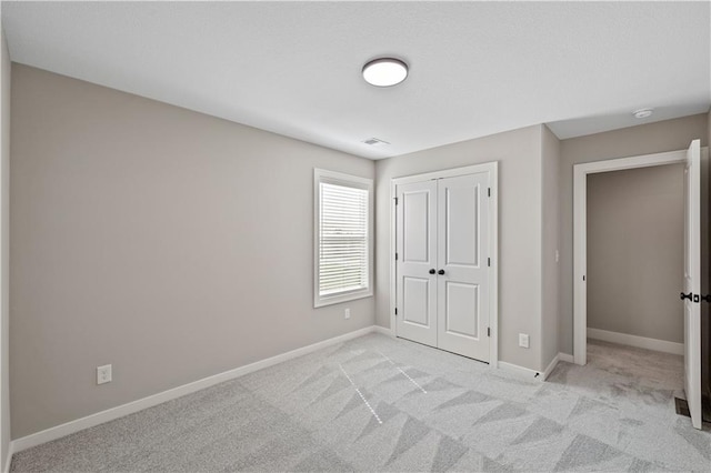 unfurnished bedroom featuring a closet and light carpet