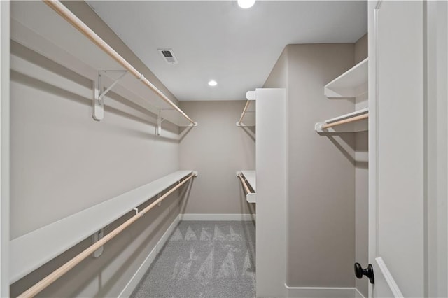 walk in closet featuring light colored carpet