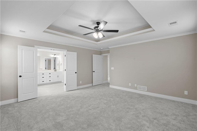 unfurnished bedroom featuring visible vents, a tray ceiling, and baseboards