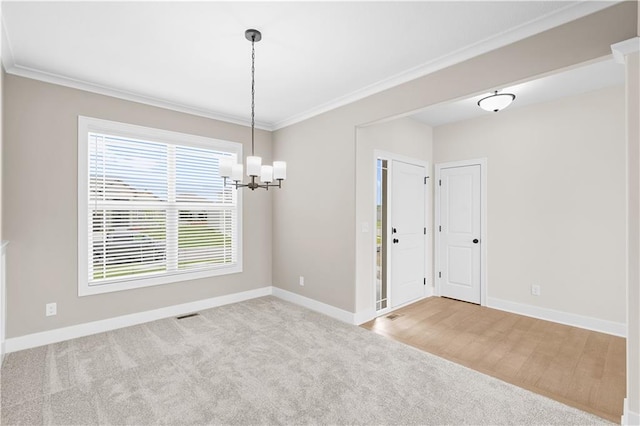 unfurnished dining area with crown molding, a healthy amount of sunlight, an inviting chandelier, and light carpet