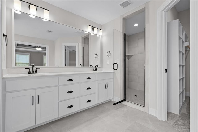 bathroom featuring ceiling fan, tile patterned flooring, dual bowl vanity, and an enclosed shower