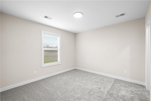 carpeted empty room with visible vents and baseboards