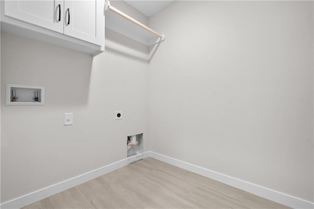 washroom featuring washer hookup, cabinet space, light wood-style floors, electric dryer hookup, and baseboards