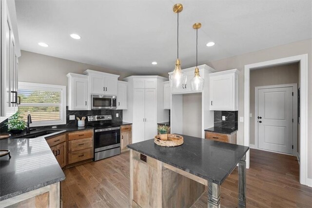 19019 W 169th Pl, Olathe, KS 66062 - kitchen featuring tasteful backsplash, a sink, dark countertops, stainless steel appliances, and dark wood-type flooring