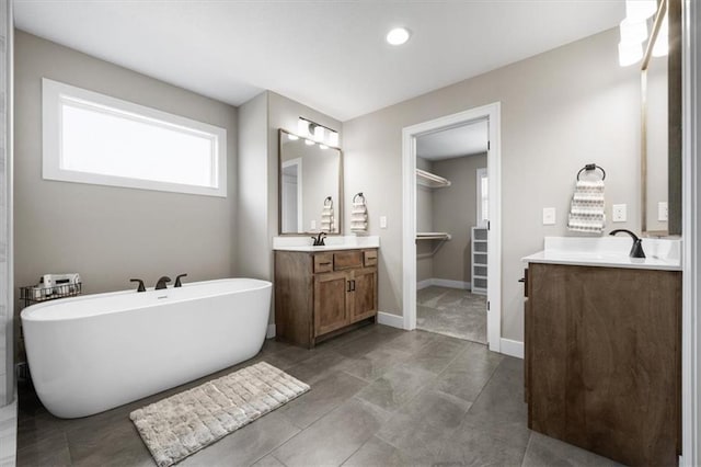 19019 W 169th Pl, Olathe, KS 66062 - bathroom with two vanities, baseboards, a sink, and a soaking tub