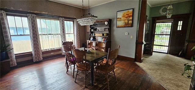 dining area featuring an inviting chandelier, dark hardwood / wood-style floors, and crown molding