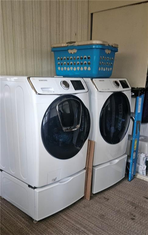 clothes washing area with dark carpet and washing machine and dryer