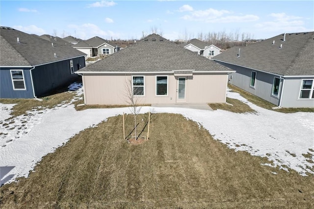 back of property with a residential view and roof with shingles