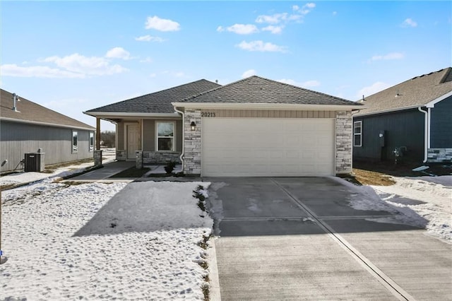 view of front facade featuring driveway, a garage, stone siding, roof with shingles, and cooling unit