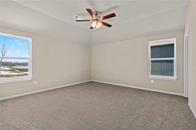 empty room featuring carpet floors, visible vents, ceiling fan, and baseboards