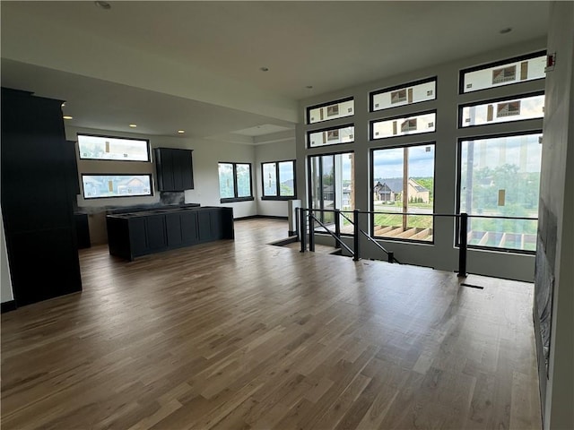 unfurnished living room with baseboards, wood finished floors, and recessed lighting