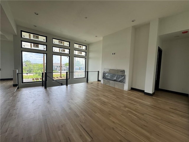 unfurnished living room featuring recessed lighting, baseboards, and wood finished floors