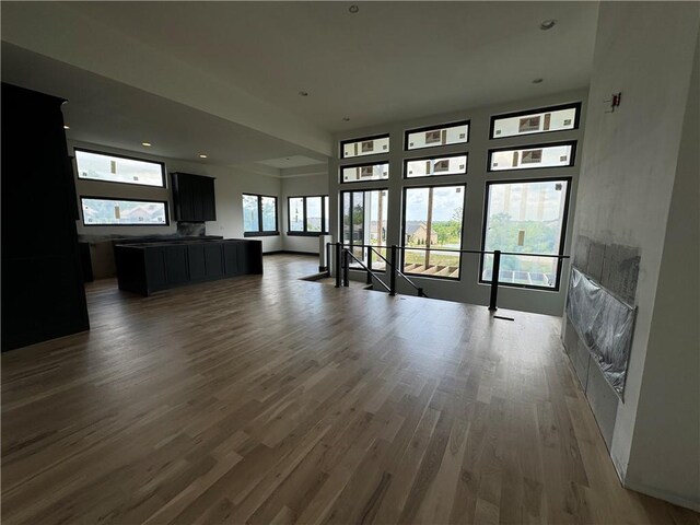 unfurnished living room with wood-type flooring and a healthy amount of sunlight