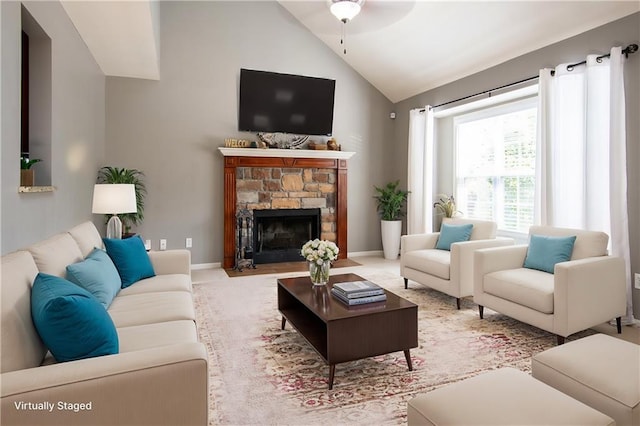 living room with ceiling fan, a stone fireplace, and high vaulted ceiling