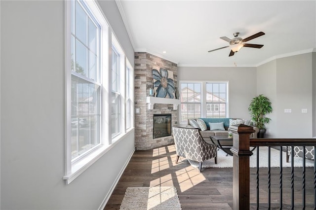 living room featuring a fireplace, ceiling fan, dark wood-type flooring, and crown molding