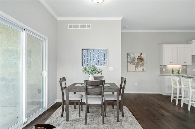 dining space with dark hardwood / wood-style flooring and crown molding