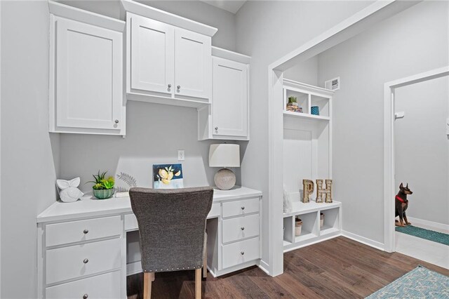 home office featuring dark wood-type flooring and built in desk