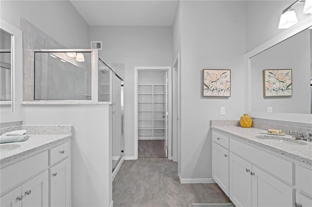 bathroom featuring tile patterned flooring, vanity, and a shower with shower door