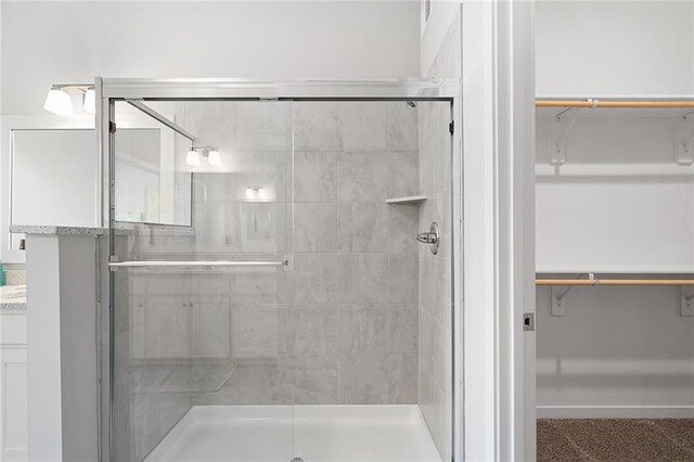 bathroom with a shower with door and vanity