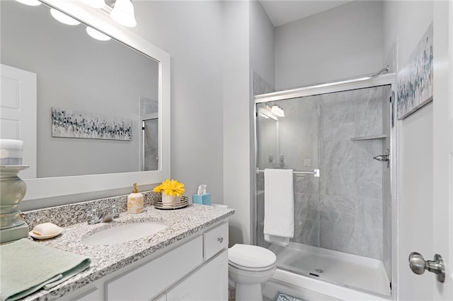 bathroom featuring toilet, vanity, and walk in shower