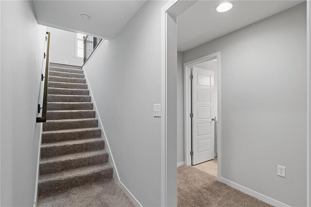 stairs featuring light colored carpet