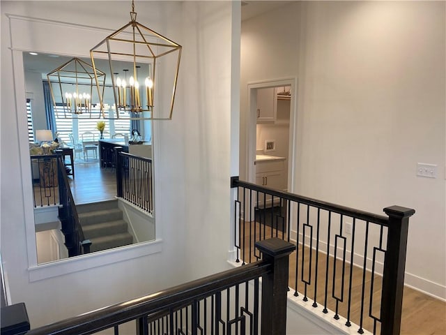 16445 S Elmridge St, Olathe, KS 66062 - hallway with an upstairs landing, a notable chandelier, baseboards, and wood finished floors