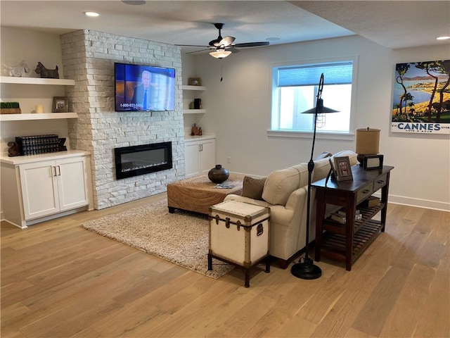 16445 S Elmridge St, Olathe, KS 66062 - living room featuring a large fireplace, baseboards, recessed lighting, light wood-style floors, and ceiling fan