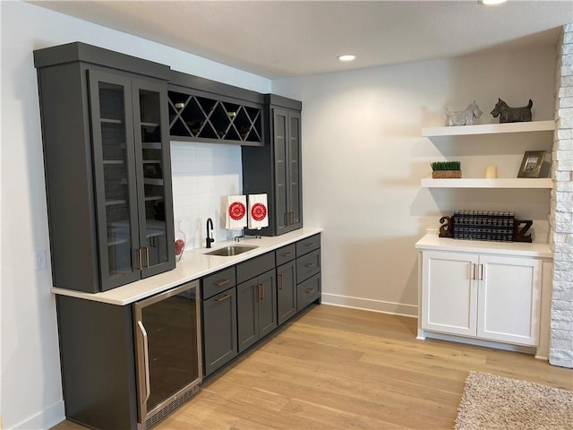 16445 S Elmridge St, Olathe, KS 66062 - bar with baseboards, indoor wet bar, a sink, light wood-style flooring, and beverage cooler