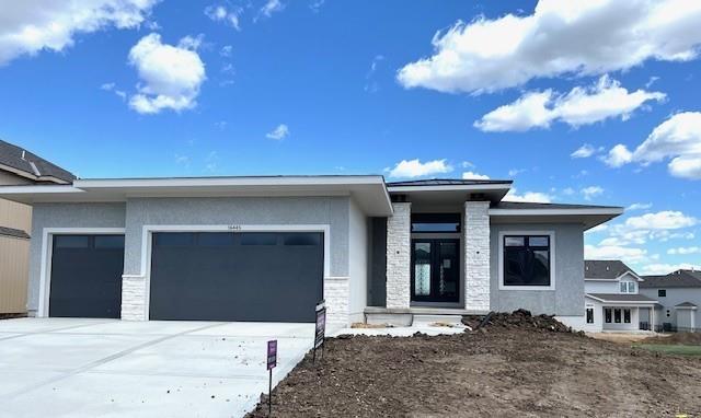 16445 S Elmridge St, Olathe, KS 66062 - view of front of house with an attached garage, driveway, stucco siding, and stone siding