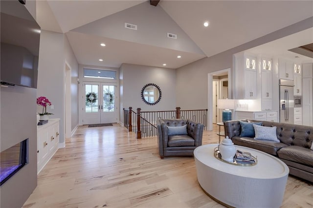 living room featuring french doors, high vaulted ceiling, and light hardwood / wood-style floors