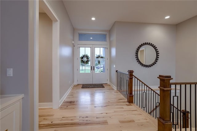 entrance foyer with french doors and light hardwood / wood-style floors