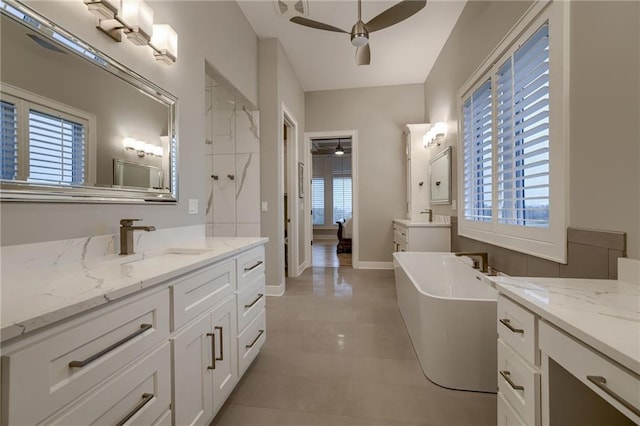 bathroom with a wealth of natural light, vanity, a bath, and ceiling fan