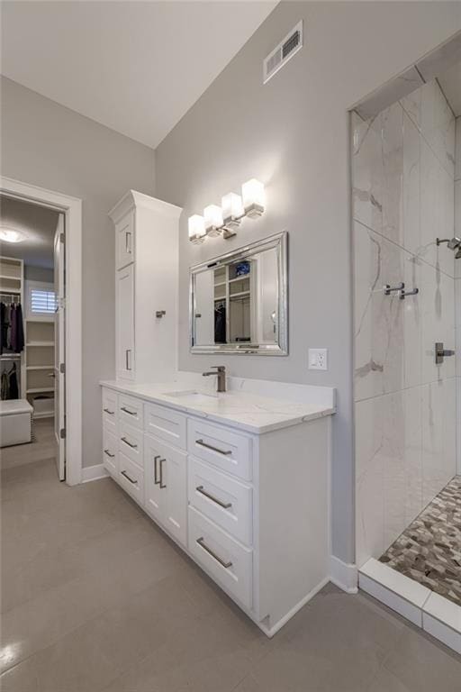 bathroom with vanity and tiled shower